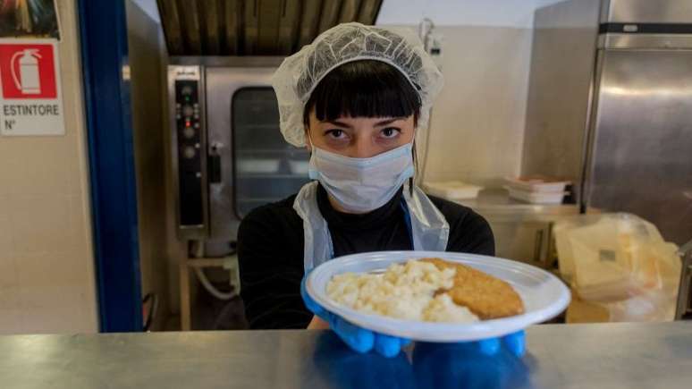 Voluntários na Itália distribuem comida para as pessoas que vivem nas ruas