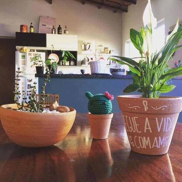 25- Na decora&ccedil;&atilde;o r&uacute;stica, o vaso cer&acirc;mico natural com L&iacute;rio da Paz decora a mesa. Fonte: Joana UnterKircher