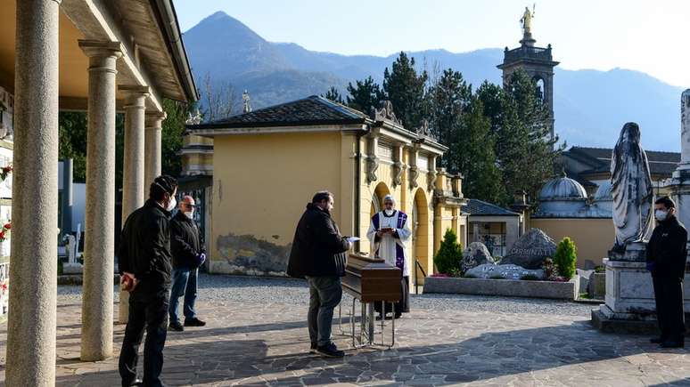 Sacerdotes celebram serviços funerários sem parentes na Itália.