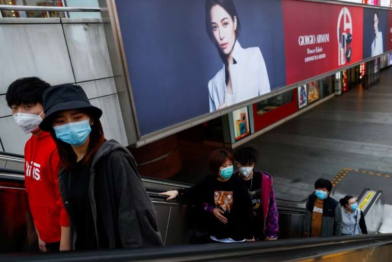 Pessoas caminham por shopping em Pequim, na China, utilizando máscaras de proteção 
25/03/2020
REUTERS/Thomas Peter