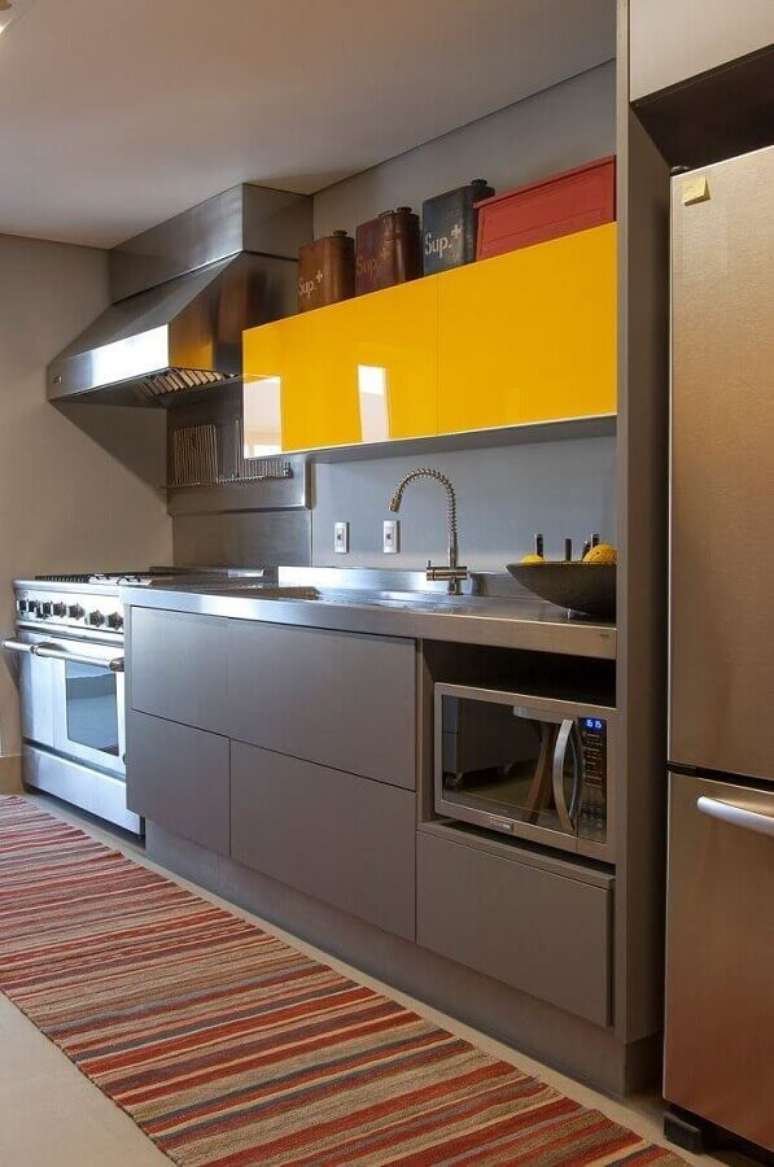 40. Cozinha compacta planejada decorada com armário aéreo amarelo e gabinete cinza – Foto: AMC – Arquitetura
