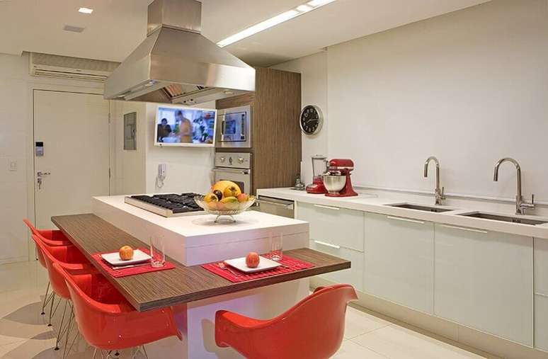 64. Decoração em cores neutras para cozinha com ilha planejada com cooktop e bancada de madeira para refeições – Foto: Pinterest