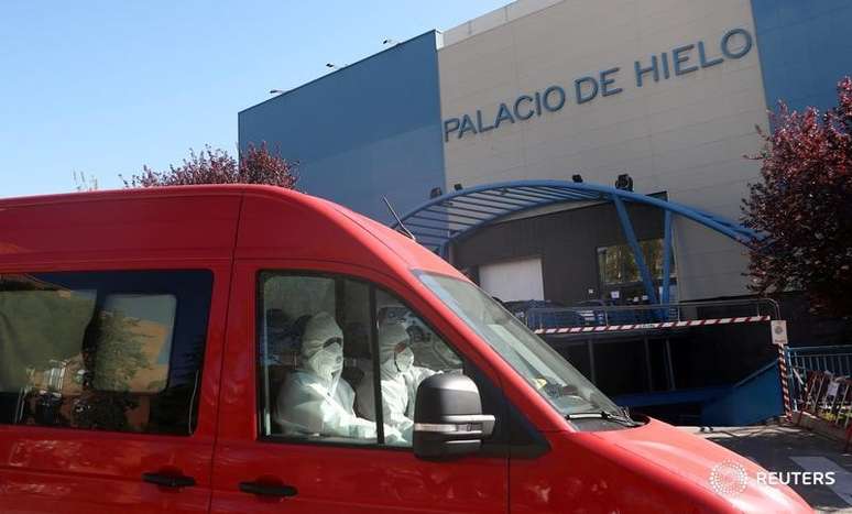 Membros do Ex&eacute;rcito da Espanha vestindo trajes de prote&ccedil;&atilde;o deixam ringue de patina&ccedil;&atilde;o no gelo que est&aacute; sendo usado como necrot&eacute;rio em Madri
26/03/2020 REUTERS/Susana Vera 