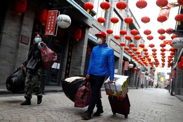 Pessoas usando máscaras de proteção caminham em distrito histórico de Pequim
26/03/2020 REUTERS/Thomas Peter