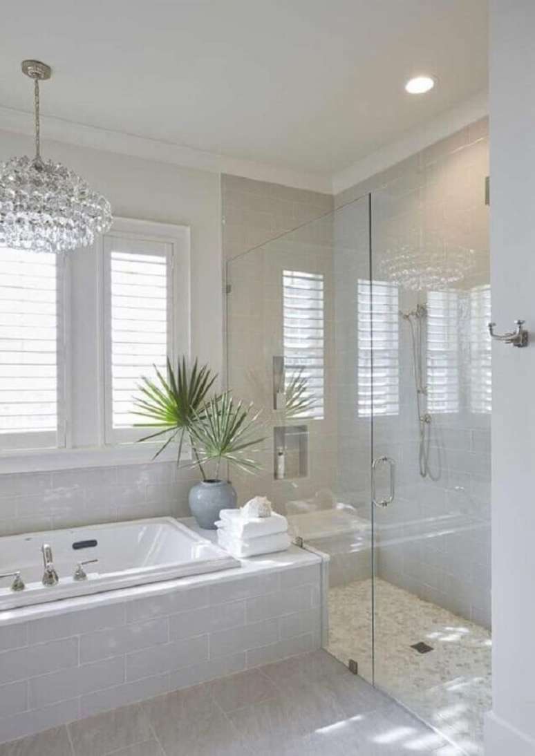 31. Lustre de cristal para decora&ccedil;&atilde;o de banheiro todo branco com banheira de hidromassagem &ndash; Foto: Pinterest