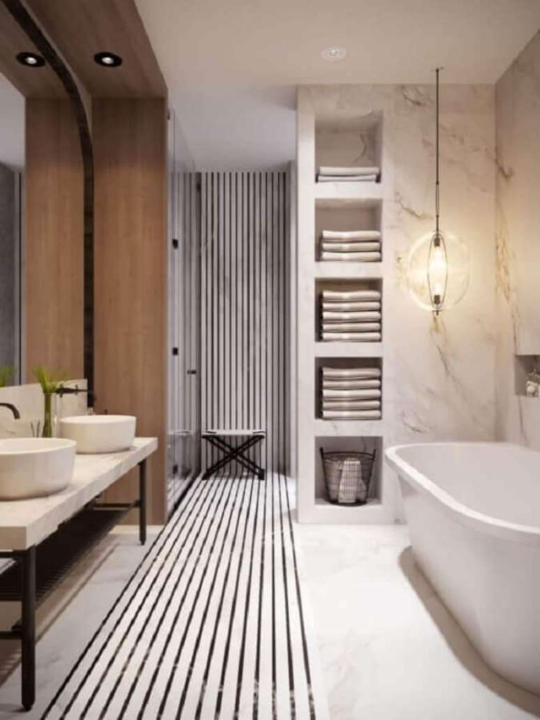 43. Lustre para banheiro decorado com banheira e tapete listrado &ndash; Foto: Dicas Decor