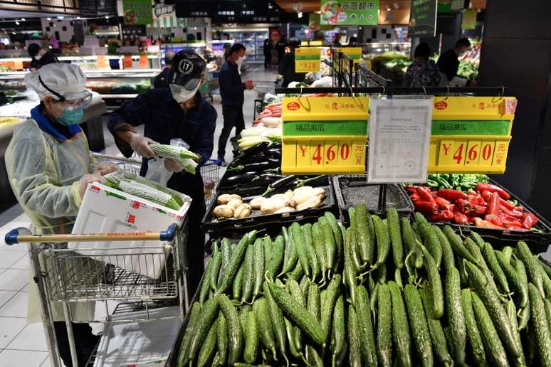 Pessoas com máscaras de proteção compram vegetais em supermercado em Wuhan
26/03/2020
REUTERS/Stringer