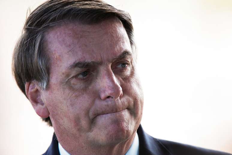 O presidente do Brasil, Jair Bolsonaro, reage ao encontrar partidários ao deixar o Palácio da Alvorada, enquanto a propagação da doença do coronavírus (Covid-19) continua em Brasília, Brasil. 30/03/2020. REUTERS/Ueslei Marcelino.