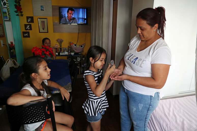 Jovem garota aplica álcool gel em sua mãe em São Paulo (SP) durante pandemia de coronavírus 
19/03/2020
REUTERS/Amanda Perobelli