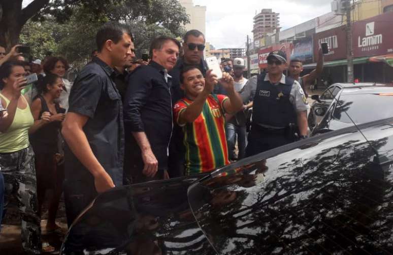 O presidente Jair Bolsonaro é assediado por apoiadores ao visitar vários comércios locais ainda abertos em Brasília, na manhã deste domingo, 29 de março de 2020. Bolsonaro saiu por volta de 9h30 do Palácio da Alvorada e seguiu para um posto de gasolina. Ele desceu do carro para cumprimentar e tirar fotos com frentistas que estavam trabalhando. 