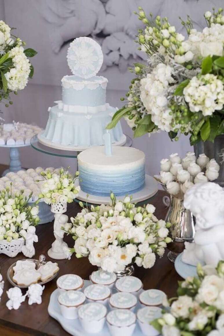 44. Delicada decoração com vários arranjos de flores para decoração de mesa de batizado azul e branca – Foto: Vida de Mãe