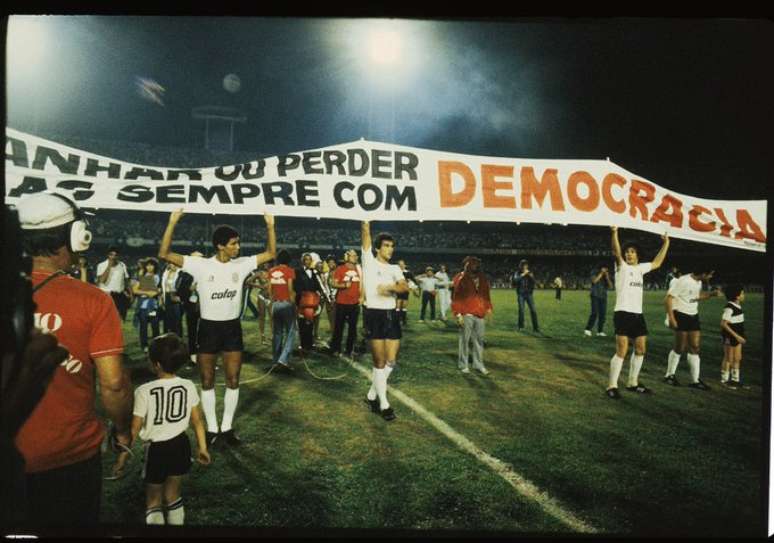 Na final do Campeonato Paulista de 83, os jogadores do Corinthians entraram com a faixa: ganhar ou perder, mas sempre com Democracia