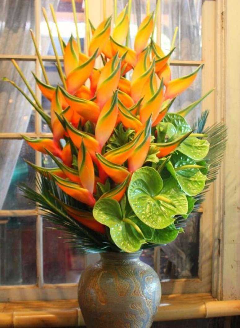 58. Vasos com arranjos maiores de flores tropicais são bem interessantes em uma decoração – Foto: Via Pinterest