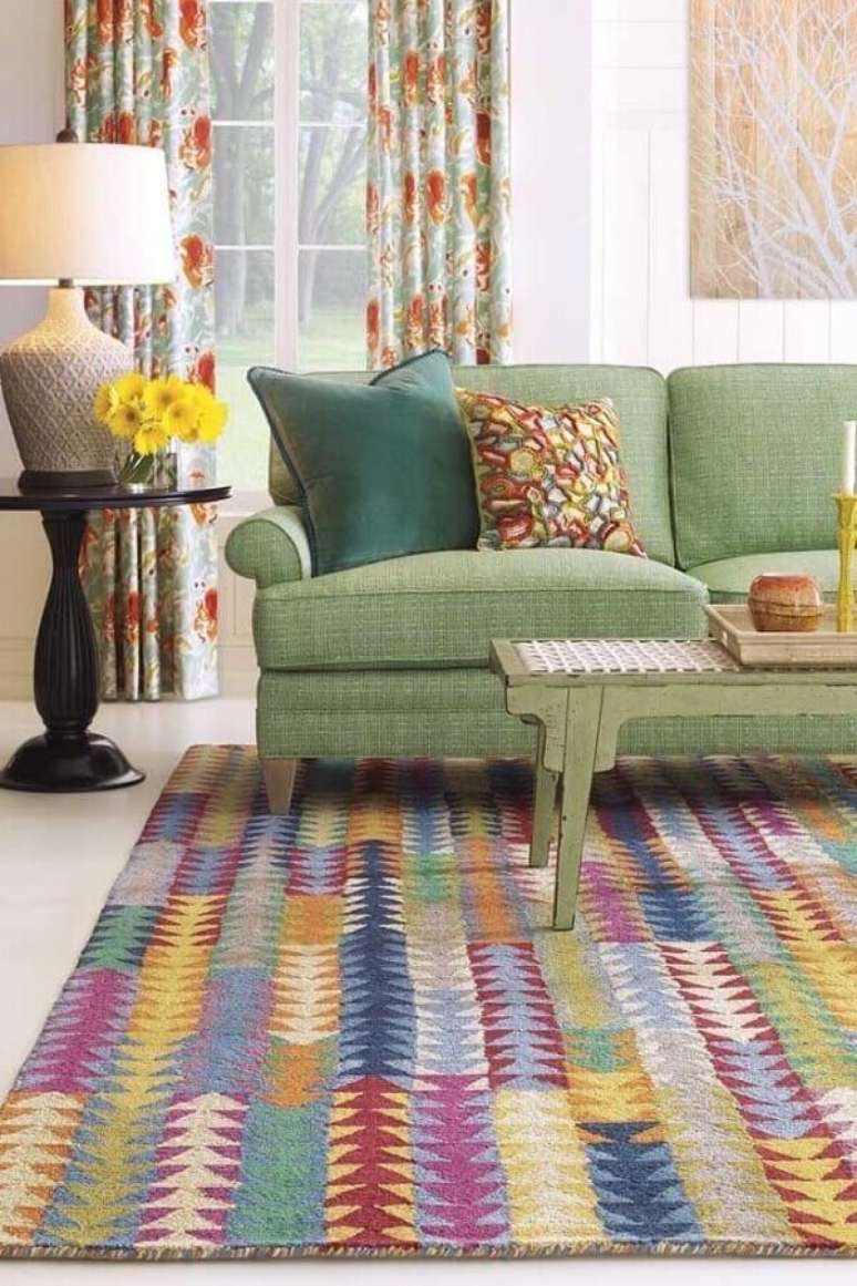 33. Sofá verde e tapete de retalhos coloridos complementam a decoração da sala de estar. Fonte: Pinterest