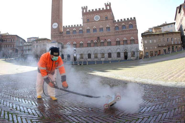 Operador sanitário faz higienização da Piazza del Campo, em Siena