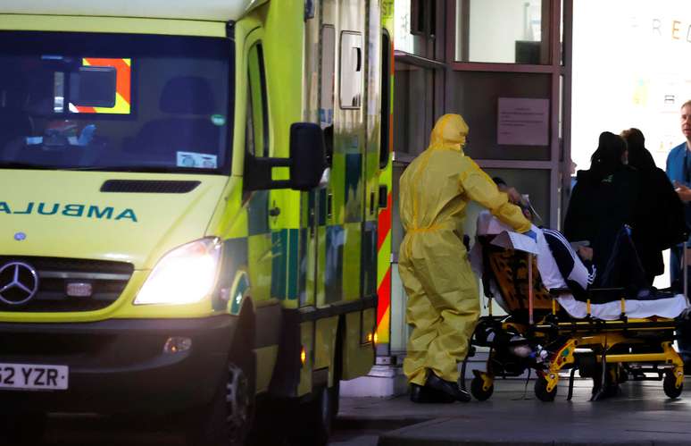 Um trabalhador do setor de sa&uacute;de empurra um paciente em uma maca no lado de fora do Royal Liverpool University Hospital em Liverpool, Inglaterra. 02/04/2020. REUTERS/Phil Noble.