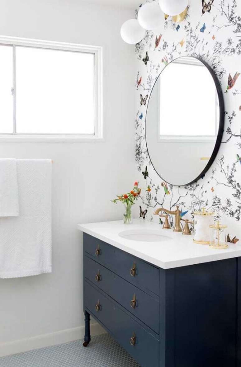 18. Decora&ccedil;&atilde;o clean com papel de parede para banheiro branco decorado com espelho redondo e gabinete azul marinho &ndash; Foto: Futurist Architecture