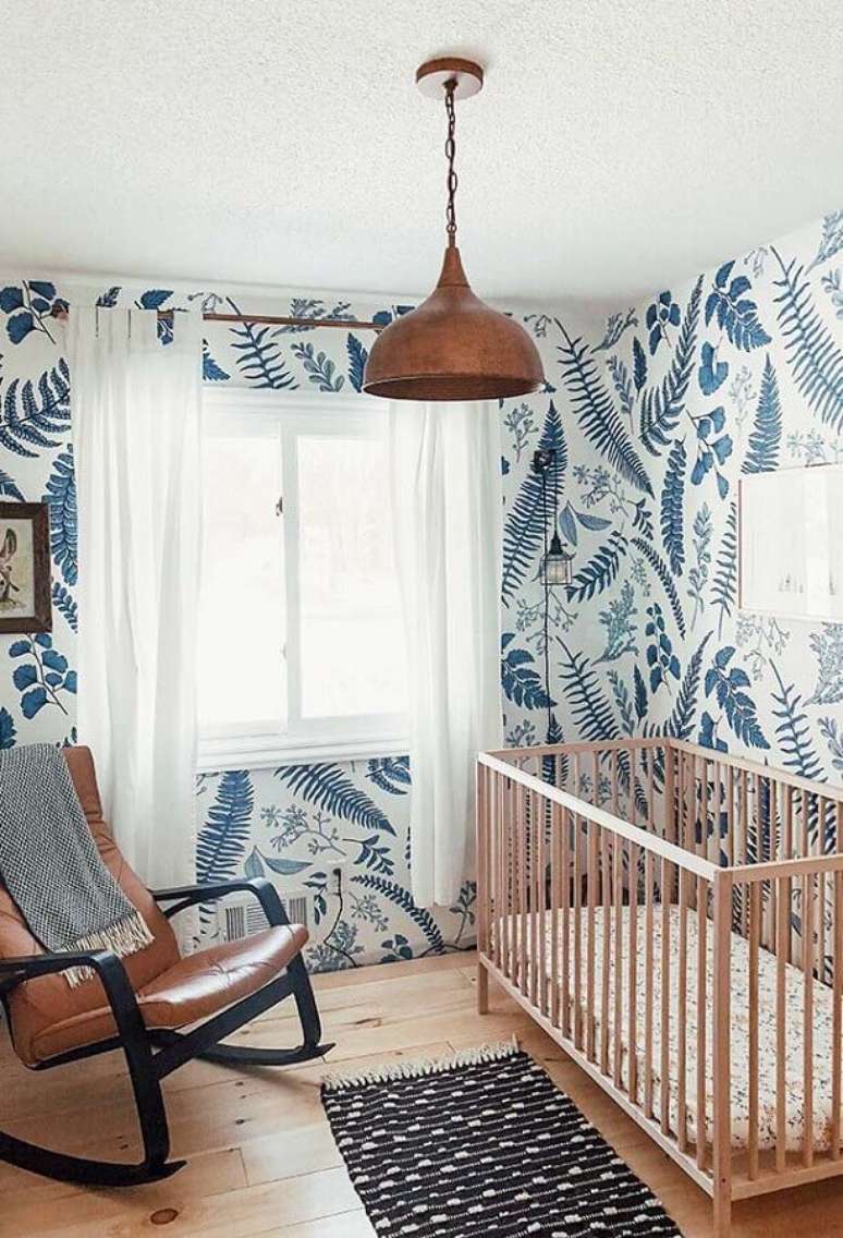 84. Papel de parede para quarto de beb&ecirc; simples decorado com ber&ccedil;o de madeira e cadeira de balan&ccedil;o de couro &ndash; Foto: Casa Tr&egrave;s Chic