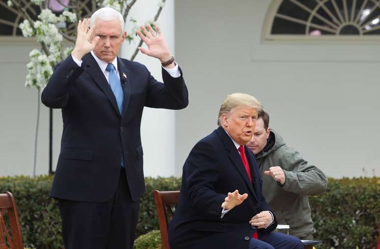 O vice-presidente dos Estados Unidos, Mike Pence, e o presidente Donald Trump reagem enquanto se preparam para participar de um evento. 24/03/2020. REUTERS/Jonathan Ernst.