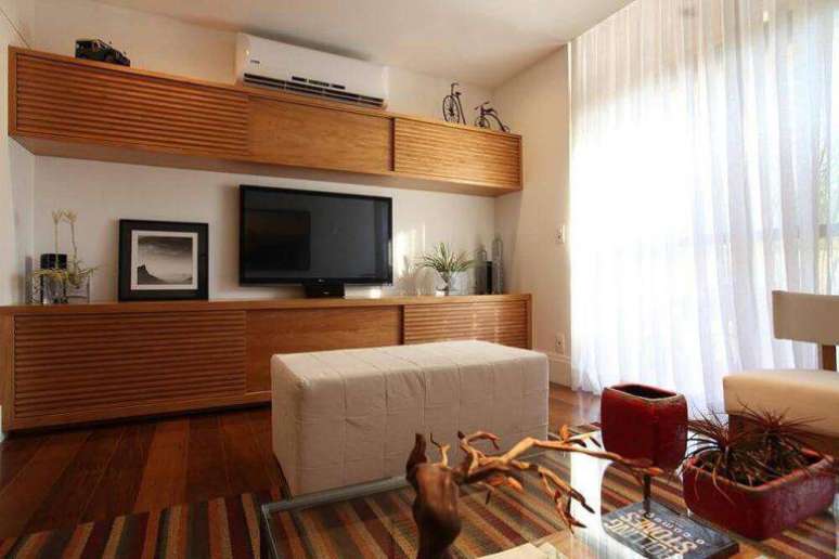 40. O rack com porta de correr economiza espa&ccedil;o na sala. Projeto por H&eacute;rcules Bassalo