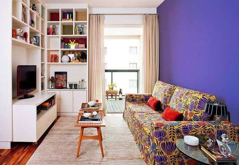 46. O rack para sala na cor branca trouxe neutralidade para a sala com sofá colorido. Fonte: Pinterest