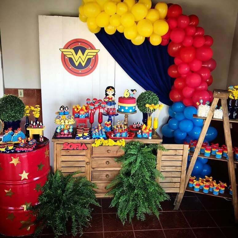 37. Decora&ccedil;&atilde;o de festa Mulher Maravilha simples com m&oacute;veis de madeira e tonal vermelho decorado com estrelas douradas &ndash; Foto: Doce de La&ccedil;o