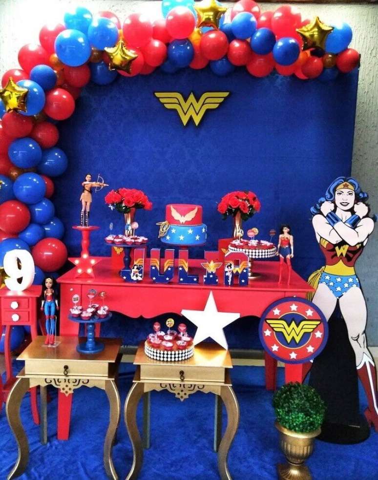 59. Painel azul decorado com bal&otilde;es para festa Mulher Maravilha com mesa vermelha e dourada &ndash; Foto: Pinterest