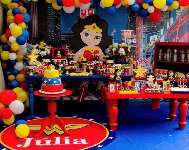 63. Linda decora&ccedil;&atilde;o com painel personalizado para festa Mulher Maravilha com mesa azul e vermelha &ndash; Foto: Ilana Santos Decora&ccedil;&otilde;es