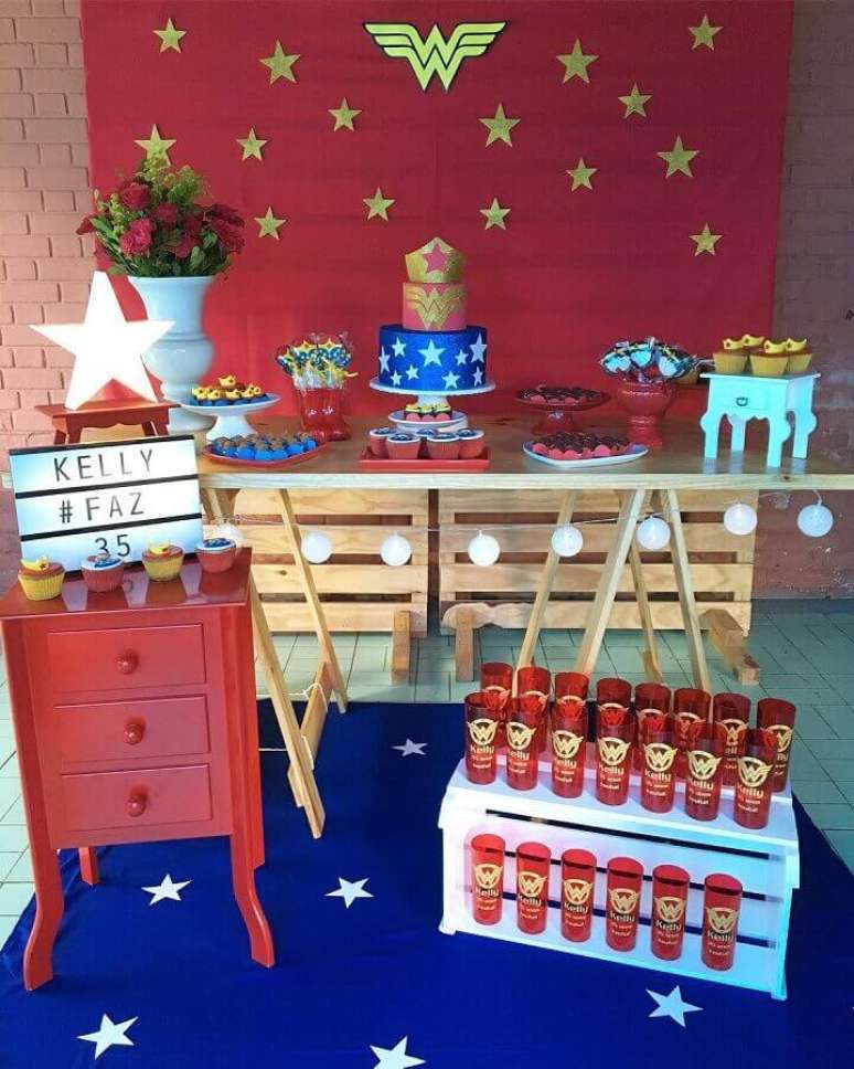 65. Painel vermelho decorado com estrelas douradas para festa Mulher Maravilha simples &ndash; Foto: Mirabella Festas