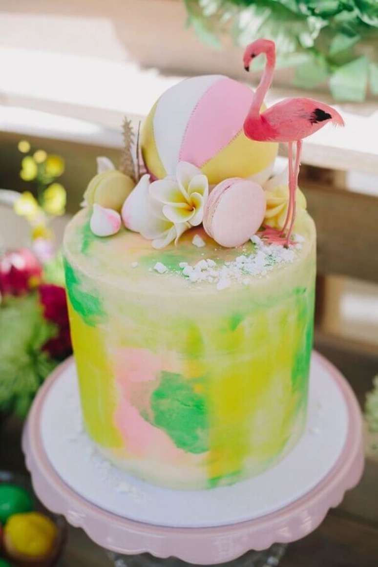 33. Bolo tropical colorido e decorado com flores e um flamingo no topo – Foto Pinterest