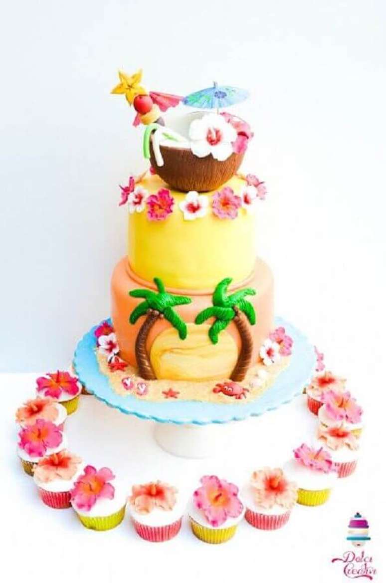 38. Linda inspiração de bolo tropical decorado com muitas flores, coqueiros e um coco no topo para decorar festa tropical- Foto: Pinterest