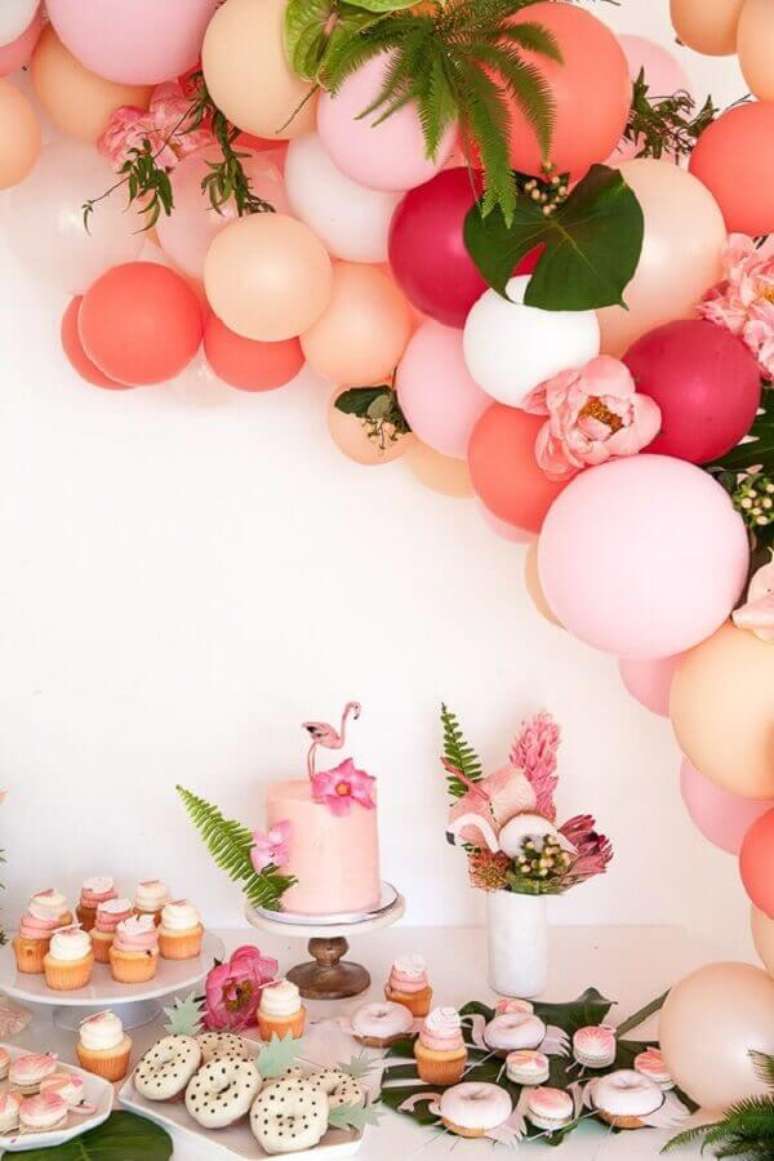 101 – Mesa decorada em tons de rosa com balões e folhagens para festa flamingo tropical – Foto: Celebrations Cake Decorating