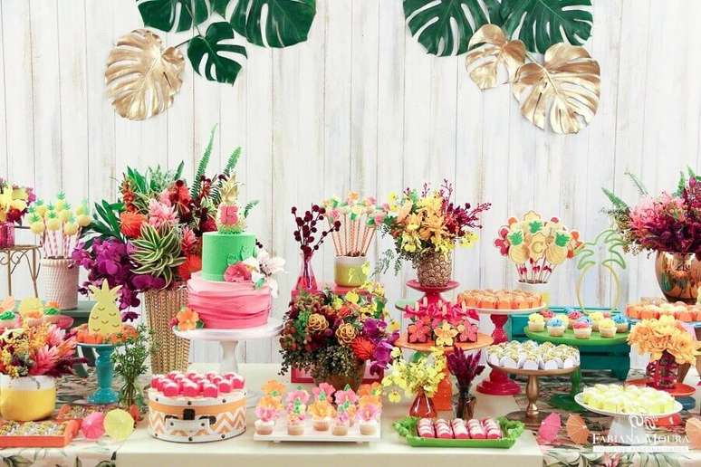 106. Linda mesa de festa tropical decorada com muitos arranjos de flores e doces – Foto: Pinterest