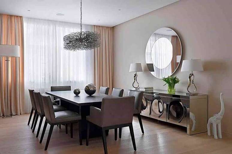 27. Decoração de sala de jantar com buffet espelhado e espelho redondo combinando com o design do móvel. Fonte: Pinterest
