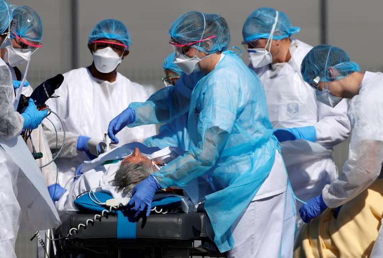 Equipe de resgate francesa vestindo roupas de proteção leva um paciente do hospital Mulhouse antes de um transporte de helicóptero, enquanto a França enfrenta uma progressão agressiva da doença por coronavírus (COVID-19) 23/03/2020. REUTERS/Christian Hartmann