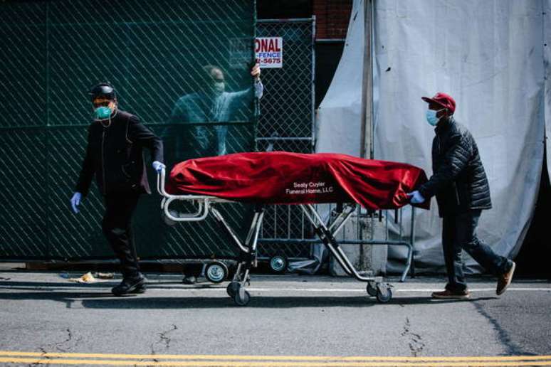 Operadores sanitários transferem corpo de vítima da Covid-19 em Nova York, epicentro da pandemia no mundo