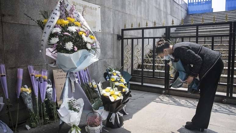 Mulher em Wuhan, cidade chinesa onde coronavírus teve origem, faz homenagem a vítimas da doença; a médica Ana Claudia Quintana Arantes alerta que pandemia traz desafios sem precedentes para o luto de milhares de pessoas