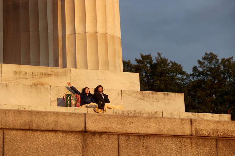 Jovem casal reza ao nascer do sol no Lincoln Memorial durante o surto de doença por coronavírus (COVID-19) em Washington