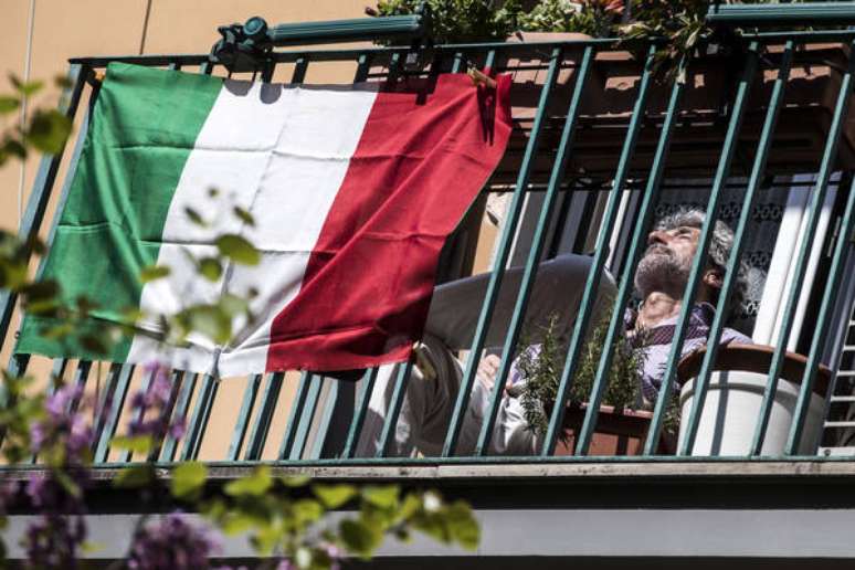 Italiano na sacada de seu apartamento em Roma