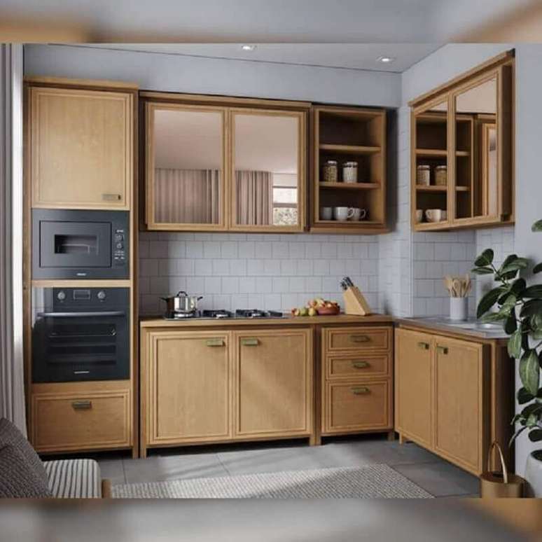 21. Armário de cozinha modulado todo em madeira com portas espelhadas em armários aéreos – Foto: Iaza