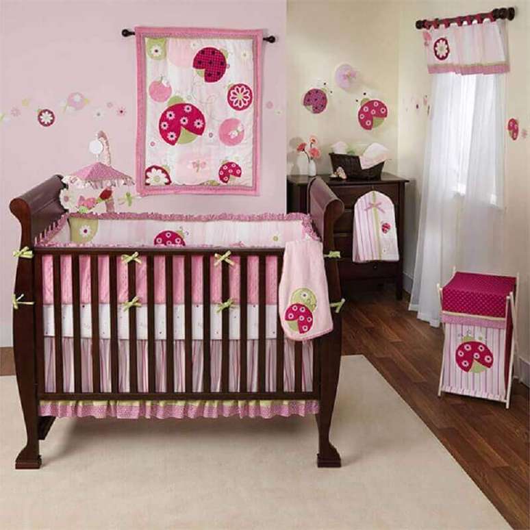29. Decoração simples de quarto de bebê rosa com berço de madeira escura – Foto: Pinterest