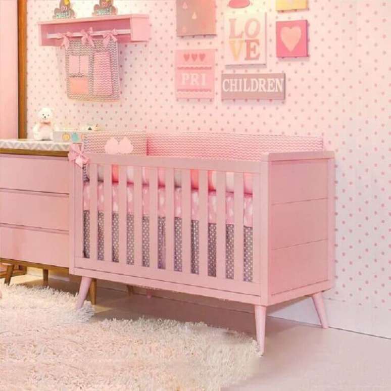 47. Quarto de bebê rosa decorado com papel de parede de bolinhas e vários quadrinhos – Foto: Pinterest
