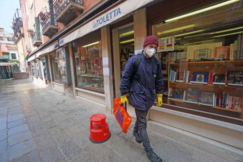 Cliente deixa a livraria La Toletta, em Veneza, após fazer uma compra