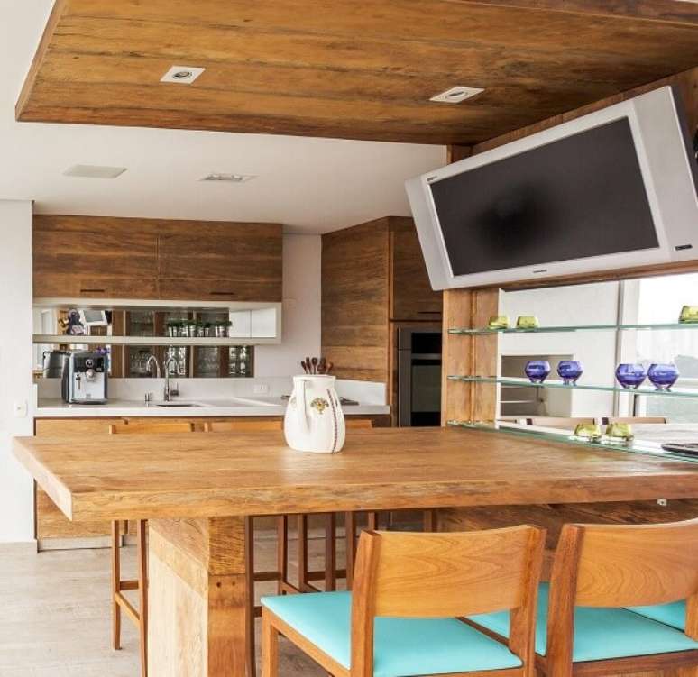 82. Ambiente planejado com m&oacute;veis r&uacute;sticos e cadeiras de madeira para cozinha. Projeto por Enzo Sobocinski