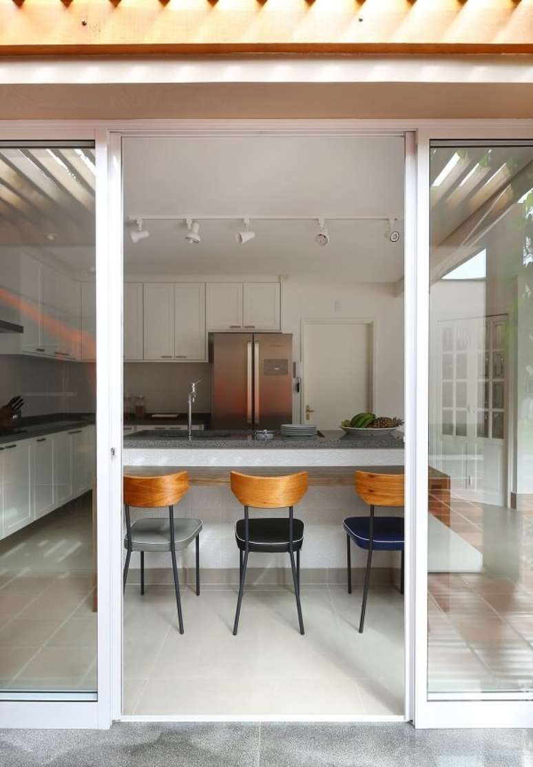 40. Cozinha com decora&ccedil;&atilde;o clean e cadeiras com acabamento de madeira. Projeto por Antonio Armando de Araujo