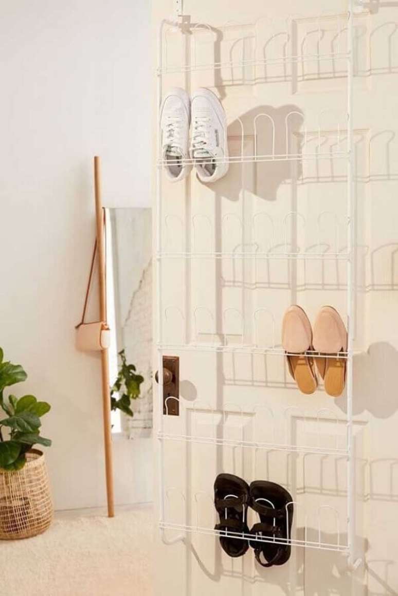 37. O aramado branco simples acomoda diversos sapatos na porta. Fonte: Pinterest