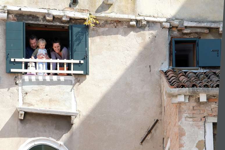 Família olha pela janela de apartamento em Veneza durante quarentena do coronavírus
17/04/2020
REUTERS/Manuel Silvestri