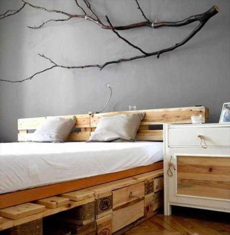 19. A decora&ccedil;&atilde;o da parede com galhos real&ccedil;a ainda mais o estilo r&uacute;stico do quarto que conta com cabeceira de cama com pallet. Fonte: Pinterest