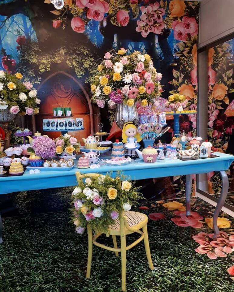 29. Decoração de festa Alice no País das Maravilhas com arranjo de flores coloridas e mesa azul – Foto: Pinterest