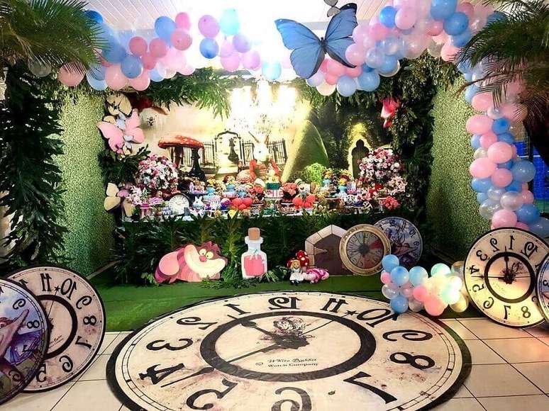 40. Detalhes para decoração de festa Alice no País das Maravilhas com grande tapete em formato de relógio e balões com borboletas – Foto: Melissa Azevedo